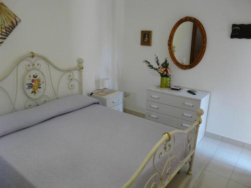 a bedroom with a bed and a dresser and a mirror at Villa Yucca in Avola