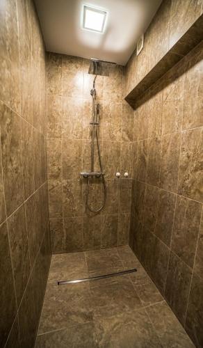 a bathroom with a shower with a stone wall at Mieterlux 22 in Klaipėda