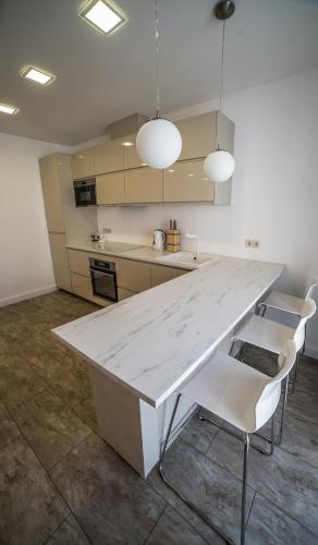 a kitchen with a large white table and chairs at Mieterlux 22 in Klaipėda