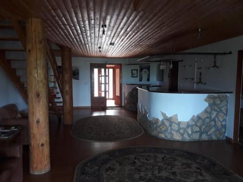 a large living room with a wooden ceiling and a table at Casa Delureni in Delureni