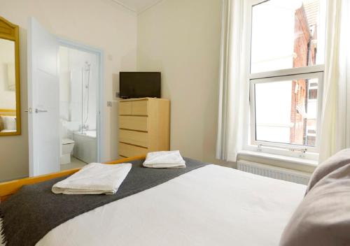 a bedroom with a bed and a television and a window at Southsea Rocks Hotel in Portsmouth