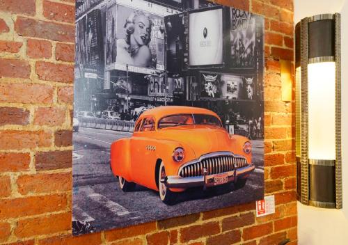 an orange car is hanging on a brick wall at Southsea Rocks Hotel in Portsmouth