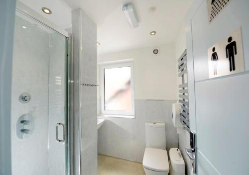 a bathroom with a shower and a toilet and a window at Southsea Rocks Hotel in Portsmouth