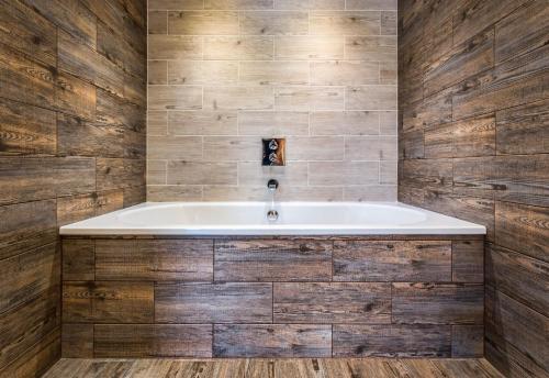 a bath tub in a bathroom with wooden walls at Skeabost House Hotel in Portree