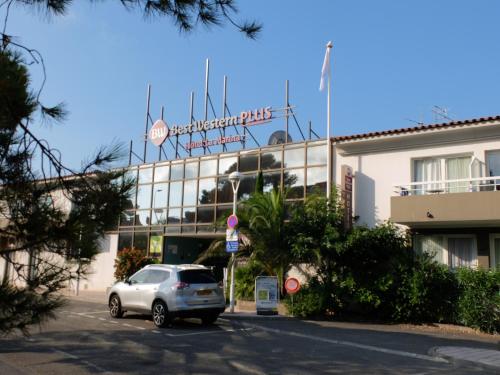 a car parked in a parking lot in front of a building at Best Western Plus La Marina in Saint-Raphaël