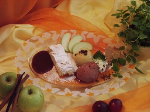 a plate of food on a table with apples at Hotel-Restaurant Fischerwirt in Gratwein
