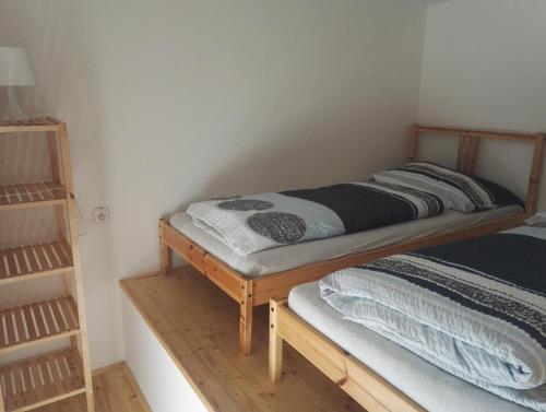 a small bedroom with a bed and a shelf at Horská chata Plzeňka Pernink in Pernink