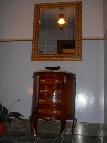 a wooden dresser with a mirror on a wall at Antico Palazzo in Giardini Naxos