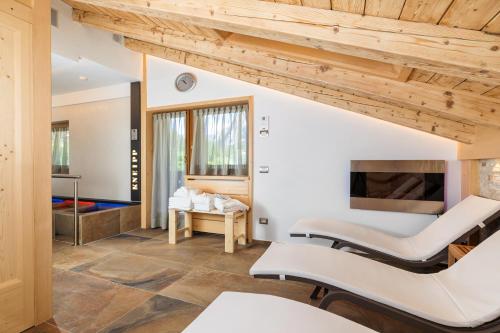 a room with two beds and a fireplace at Hotel Pontechiesa in Cortina dʼAmpezzo