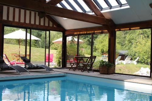 - une piscine avec des chaises, des tables et des fenêtres dans l'établissement B&B DeValpierre adult only, à Glanville