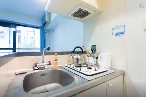 a kitchen counter with a sink and a stove at Yakuendai Wacore Elegance in Chiba
