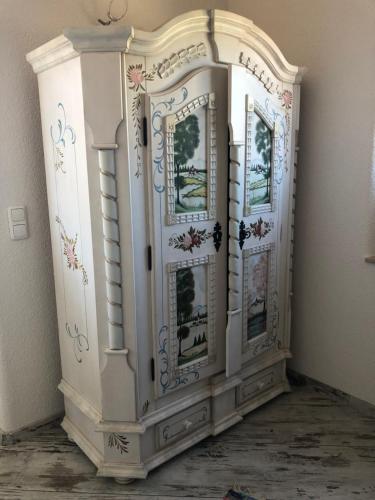a white cabinet with pictures on it in a room at Ferienhaus Eichhorn in Breege