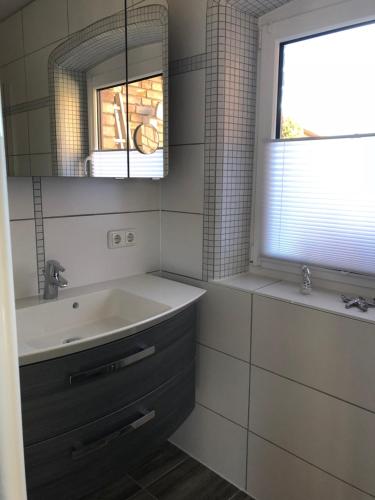 a bathroom with a sink and a mirror and a window at Ferienhaus Eichhorn in Breege