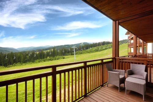 a balcony with two chairs and a view of the mountains at Radisson Blu Resort Bukovel in Bukovel