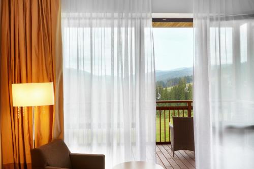 a room with a window with a view of a balcony at Radisson Blu Resort Bukovel in Bukovel