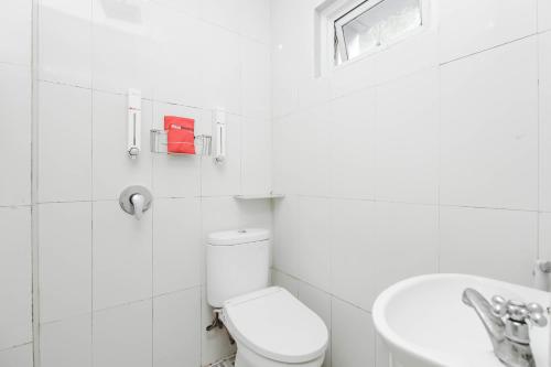 uma casa de banho branca com um WC e um lavatório em RedDoorz Plus @ Jalan Pemuda Jakarta em Jakarta