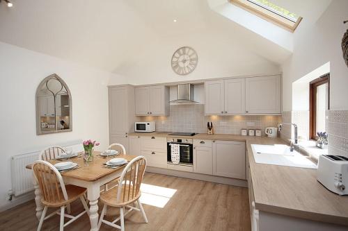 a kitchen with a table and chairs and a clock at The Old Stables in Taunton