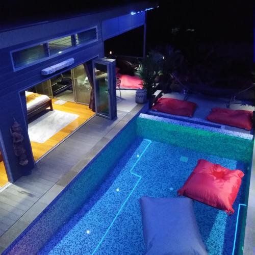 a pool in the middle of a house with pillows at Stunning villa with ocean views and free car in Lamai