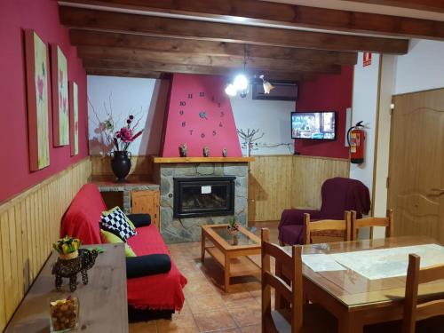 sala de estar con paredes rojas y chimenea en Alojamiento Alarcon, en Arroyo Frío