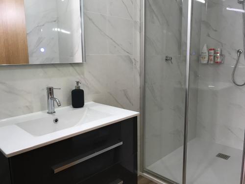 a bathroom with a sink and a shower at Povoa do Mar in Póvoa de Varzim