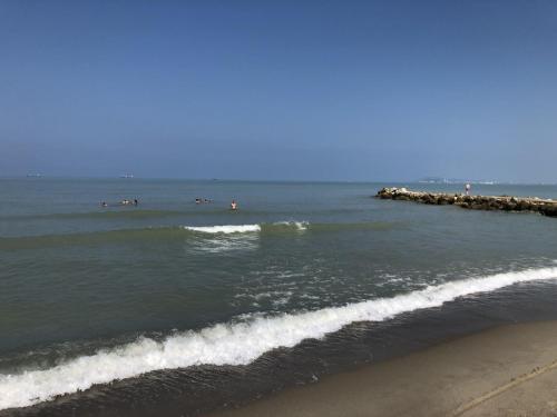 a group of people in the water at the beach at Bellavista Qerret Apartments in Golem