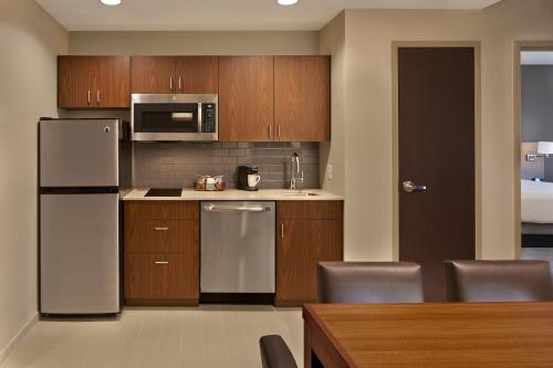 a kitchen with stainless steel appliances and wooden cabinets at Hyatt Place Warwick/Providence Airport in Warwick