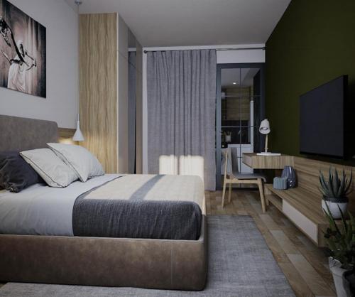 a bedroom with a bed and a desk with a television at North Avenue Loft Apartments in Yerevan