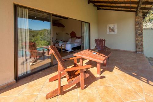 a wooden table and chairs on a patio at Lions Rock Rapids - Lodge in Hazyview