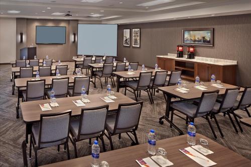 a conference room with tables and chairs and a screen at Hyatt Place Warwick/Providence Airport in Warwick
