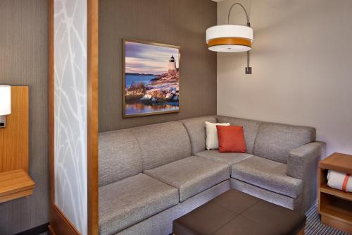 a living room with a couch and a painting at Hyatt Place Warwick/Providence Airport in Warwick