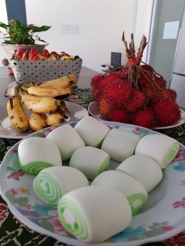 una mesa con dos platos de comida y algo de fruta en Casa Casa, en Semporna