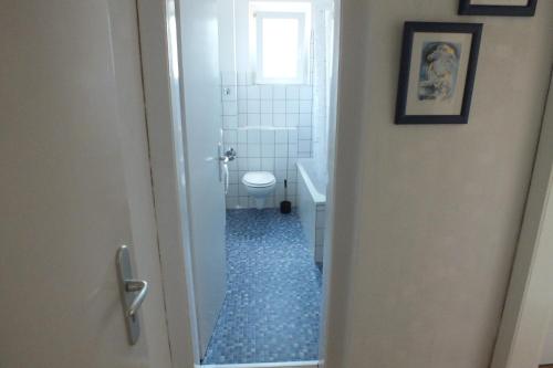 La salle de bains est pourvue de toilettes et d'une fenêtre. dans l'établissement Riverside- Monteurswohnung- Appartement in Hitdorf am Rhein, à Leverkusen