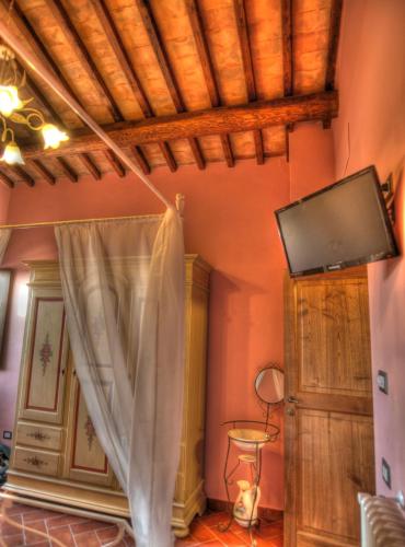 a room with a curtain and a tv on the wall at Agriturismo Podere Del Lepre in San Quirico