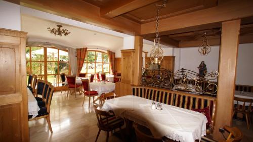 a dining room with tables and chairs and windows at Hotel Garni Obermair in Mayrhofen