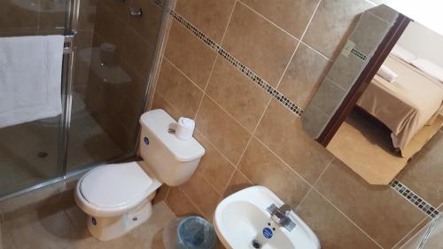 La salle de bains est pourvue de toilettes, d'un lavabo et d'une douche. dans l'établissement Hotel Kevin, à Los Santos