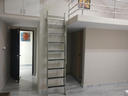 a spiral staircase in a room with a hallway at Misty Lake Guest House in Hyderabad