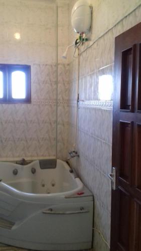 a white bath tub in a bathroom with a window at Platinum Hotels Mombasa in Shanzu