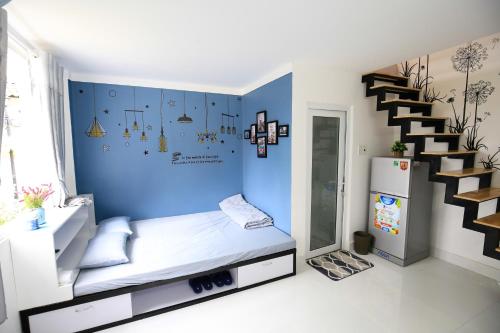 Habitación con cama y pared azul en Zan HomeStay, en Buon Ma Thuot