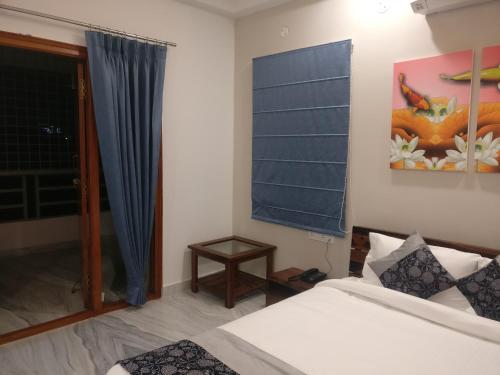 a bedroom with a bed and a window and a table at Misty Lake Guest House in Hyderabad