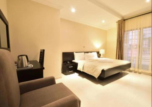 a bedroom with a bed and a couch in it at Villa Thirty Three in Lagos