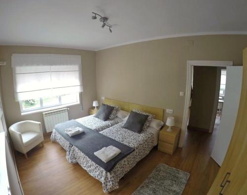 a bedroom with a bed and a chair and a window at La Posada de Granda in Cuenco