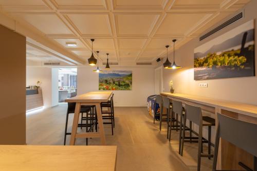 a bar in a room with stools and paintings on the wall at Vineus Tramin in Termeno