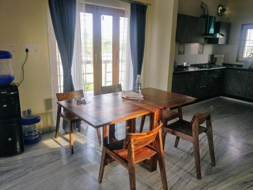 a kitchen with a wooden table and chairs and a kitchen with a window at Misty Lake Guest House in Hyderabad