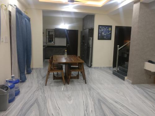a dining room with a table and a kitchen at Misty Lake Guest House in Hyderabad