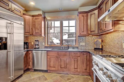una cocina con armarios de madera y electrodomésticos de acero inoxidable en 39B Union Creek Townhomes West en Copper Mountain