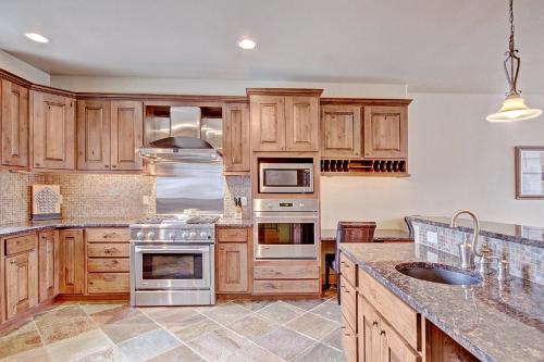 una cocina con armarios de madera y electrodomésticos de acero inoxidable en 39B Union Creek Townhomes West en Copper Mountain