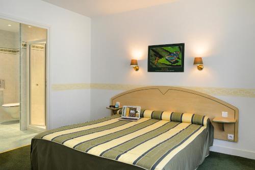 A bed or beds in a room at Logis Hôtel Restaurant La Boule d'Or