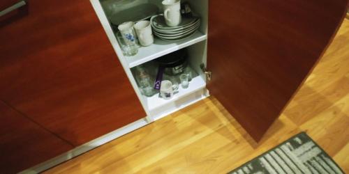a cupboard filled with plates and cups and a wooden floor at Pokoje Gościnne Polo in Częstochowa