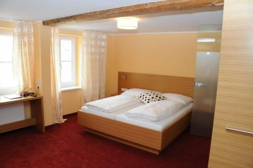 a bedroom with a bed with a wooden head board at Hotel Stiegenwirt in Schärding