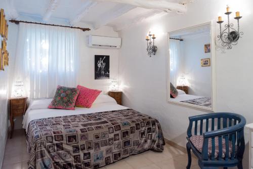 een slaapkamer met een bed, een spiegel en een stoel bij Pikes Ibiza in San Antonio